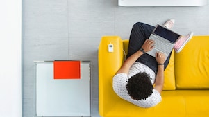 A man sitting on a sofa with his laptop